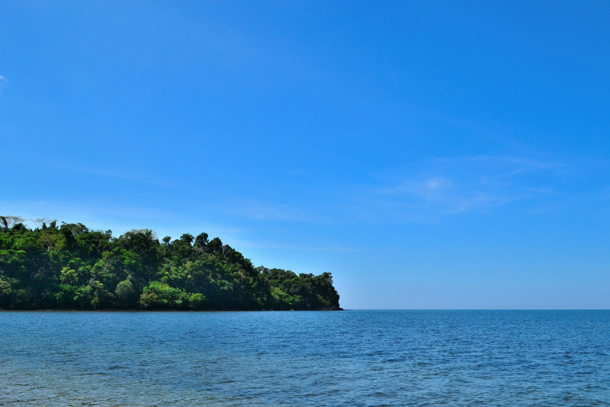 a boat sails along the shore of a large body of water