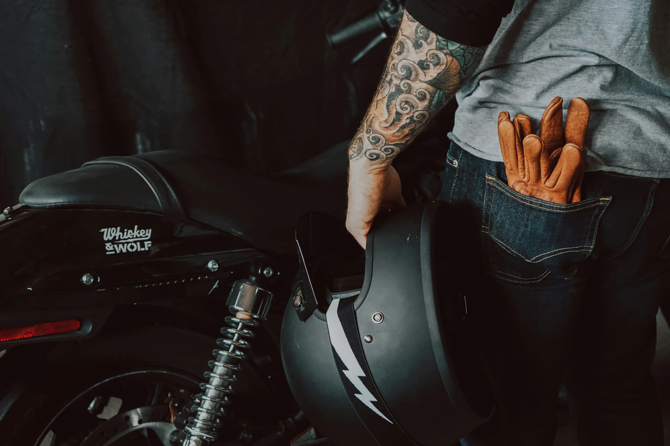 a person with tattoos and tattoos standing next to a motorcycle