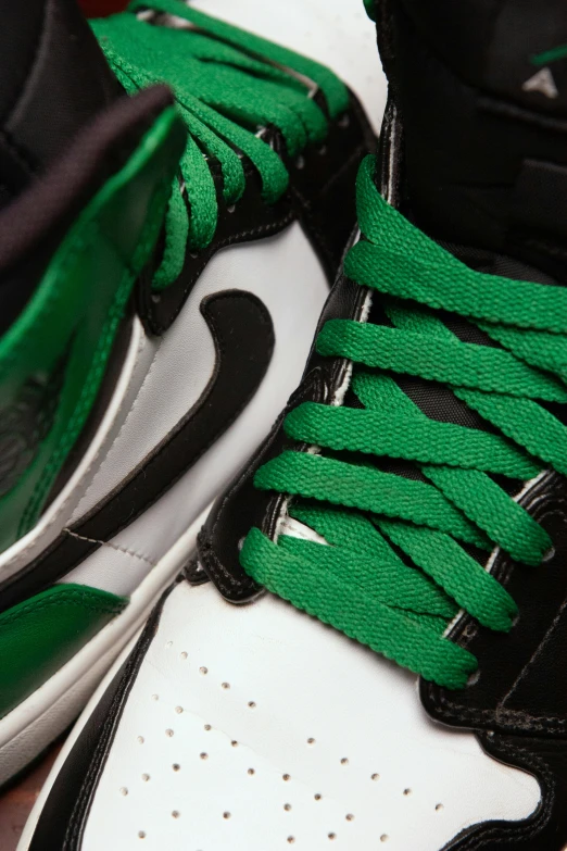 two different sneakers with green laces on them