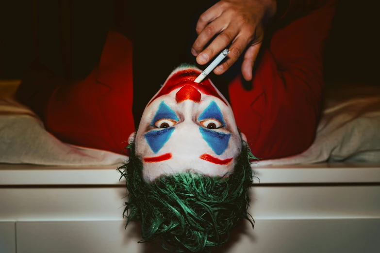 person dressed in a clown costume has painted the face of a clown