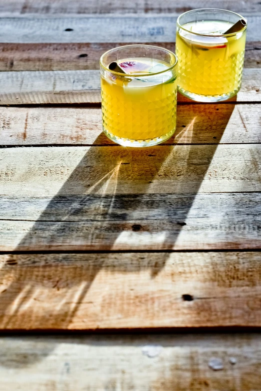 two jars of honey sitting on a wood table