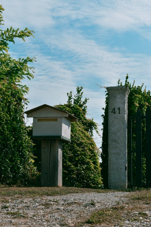 a large pillar sitting in front of a wooden structure near trees