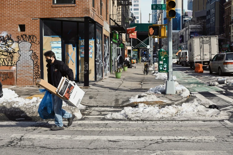 a man walking down the street carrying some items