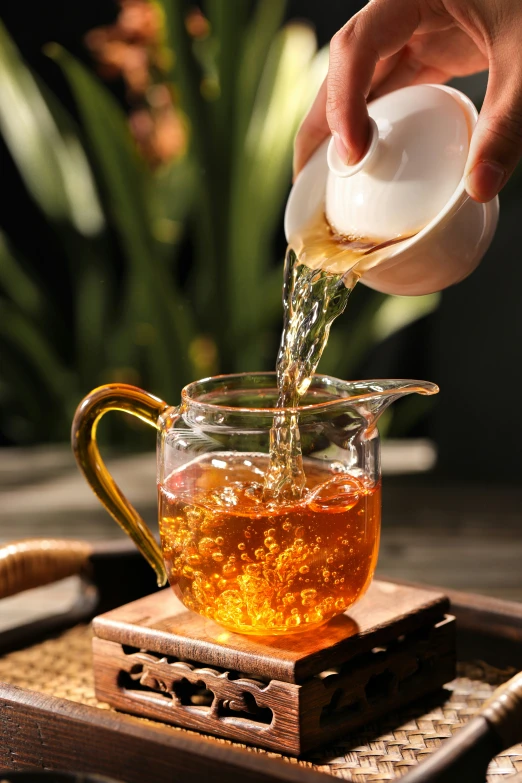 tea being poured into a glass teapot