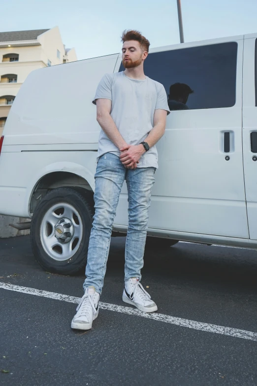 man posing for the camera in front of his van