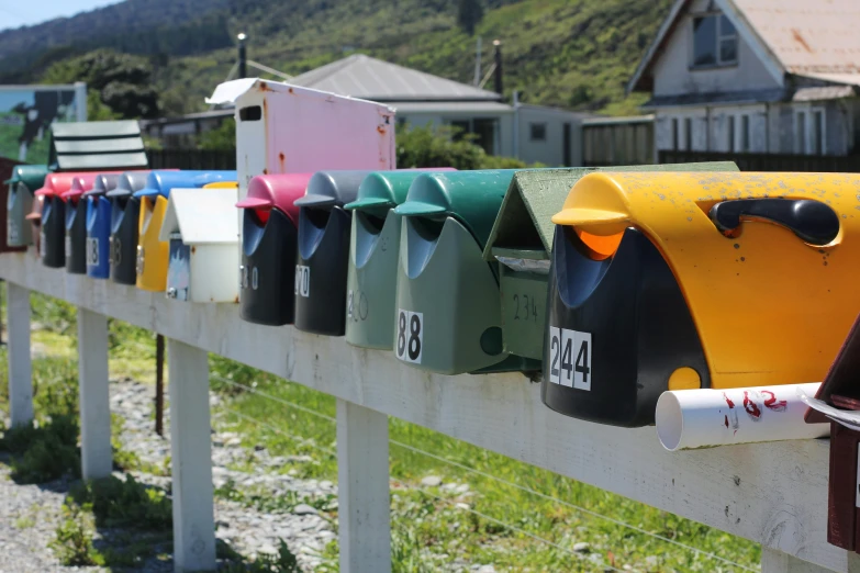 many mail boxes lined up on the side of the fence