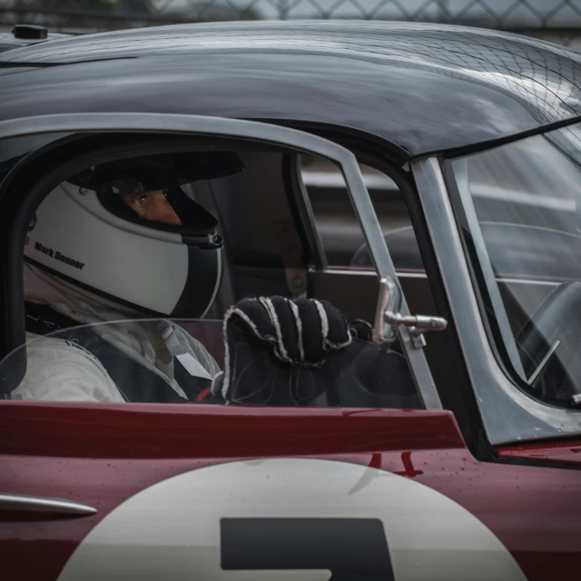 the helmeted racer takes his turn in his car