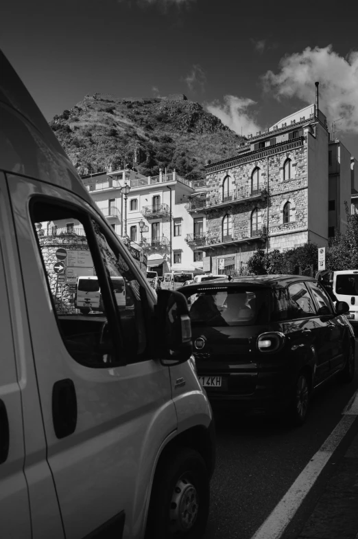 a city street with many cars and buildings on the hill