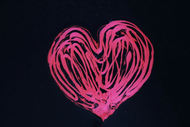 a heart - shaped object on a black background with red streaks