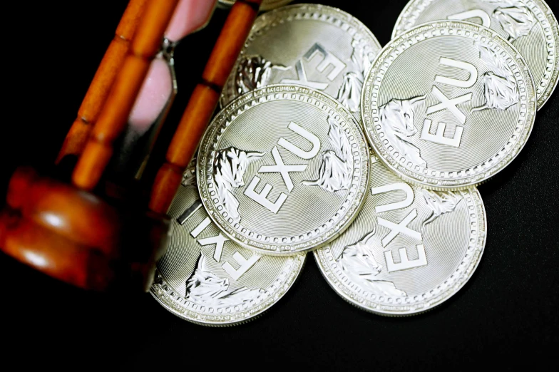 the three silver coins are next to some candles