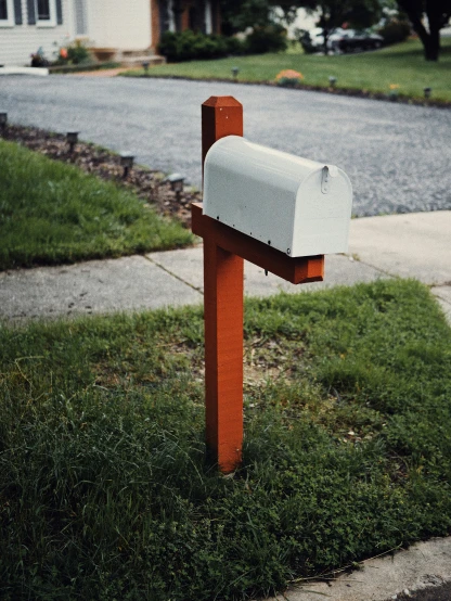 an artistic looking mail box sitting on a sidewalk