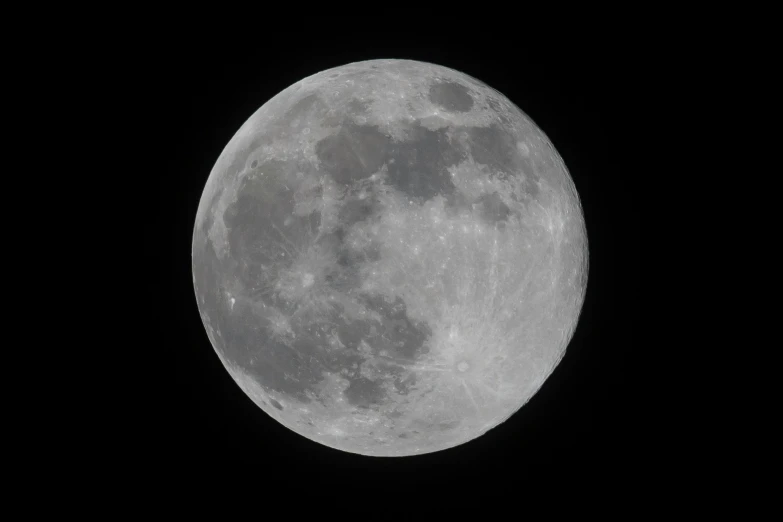 a full moon seen over the black sky