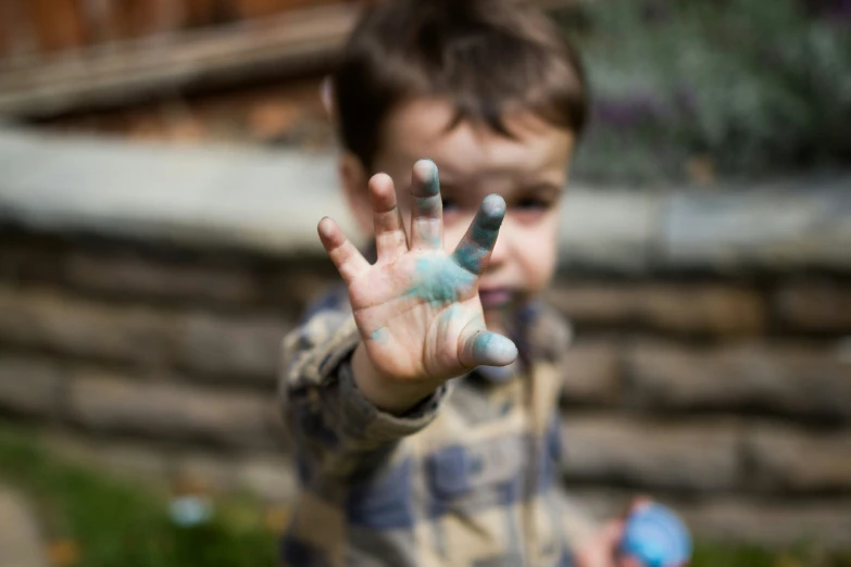 a child holding his hands out and making hand prints