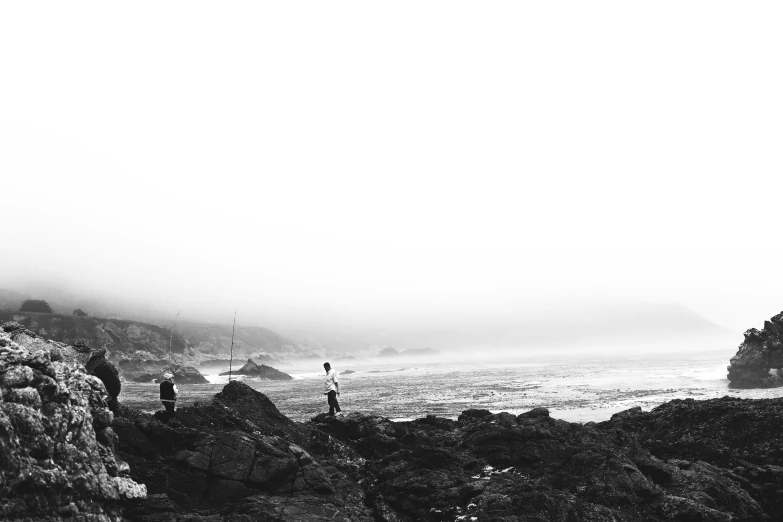 some people and the ocean near the mountains