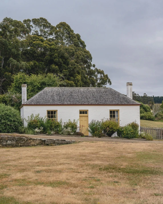 a small cottage sits in the middle of a grassy field