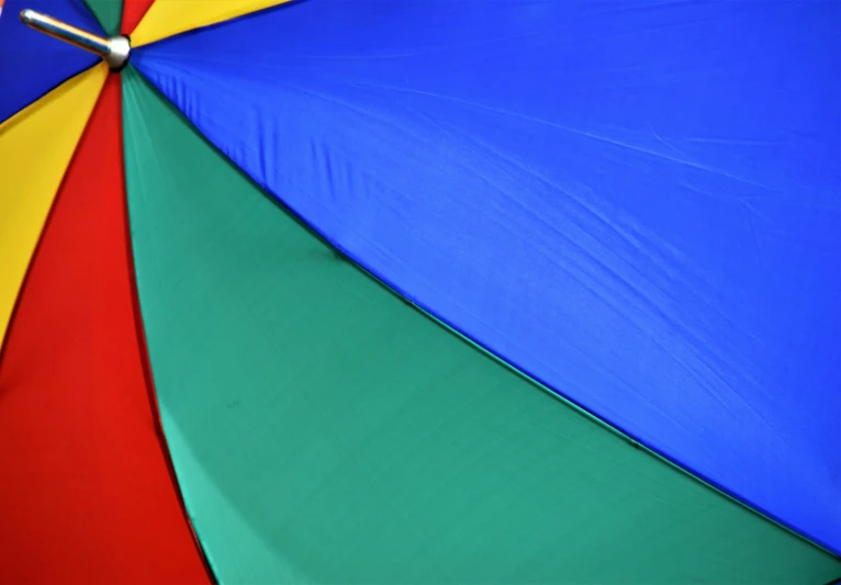 a multicolored umbrella with a silver pole on the tip