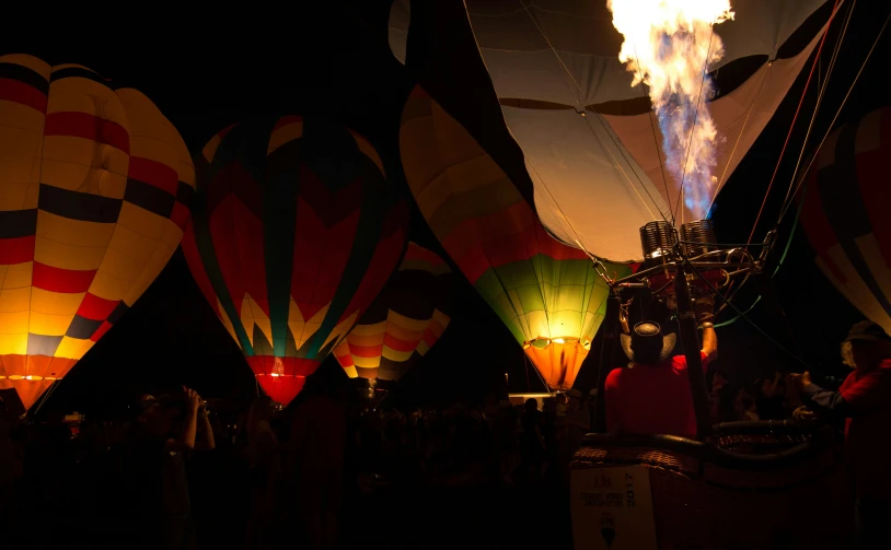 many  air balloons in the dark with lit up from above