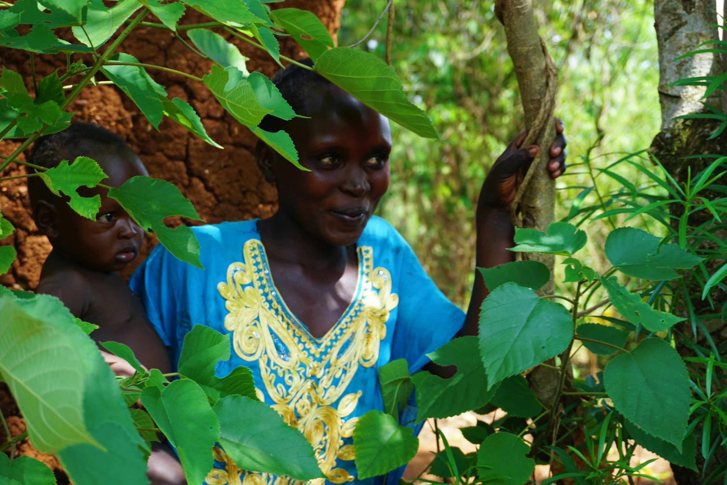 a man and a woman are standing in a clearing with leaves on their back