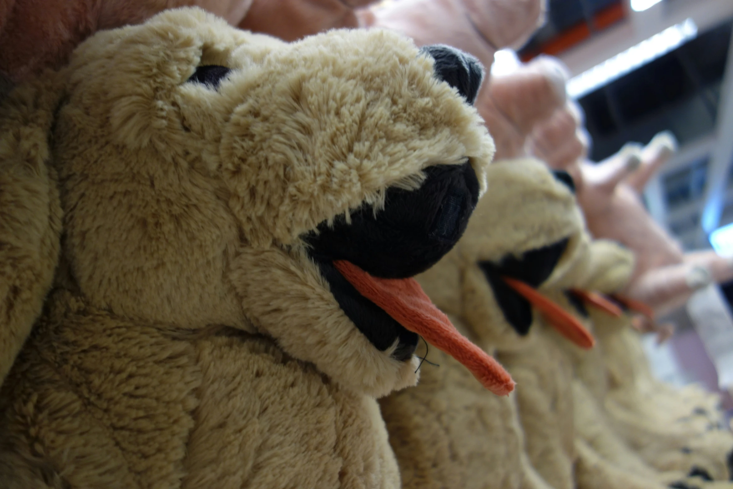 stuffed animals lined up on a rack with the mouths open