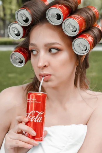 a woman wearing a coca cola hat with five cans on her head
