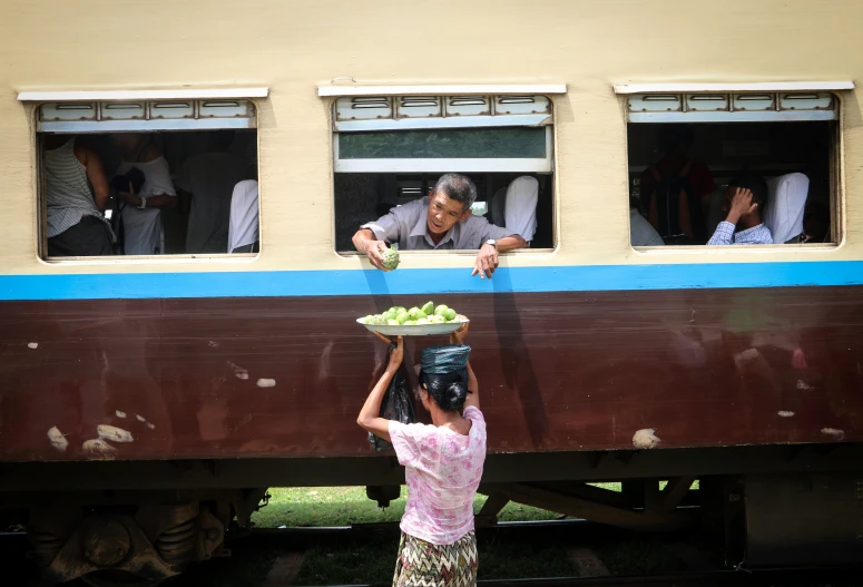 a man holding a plate of food on a train car