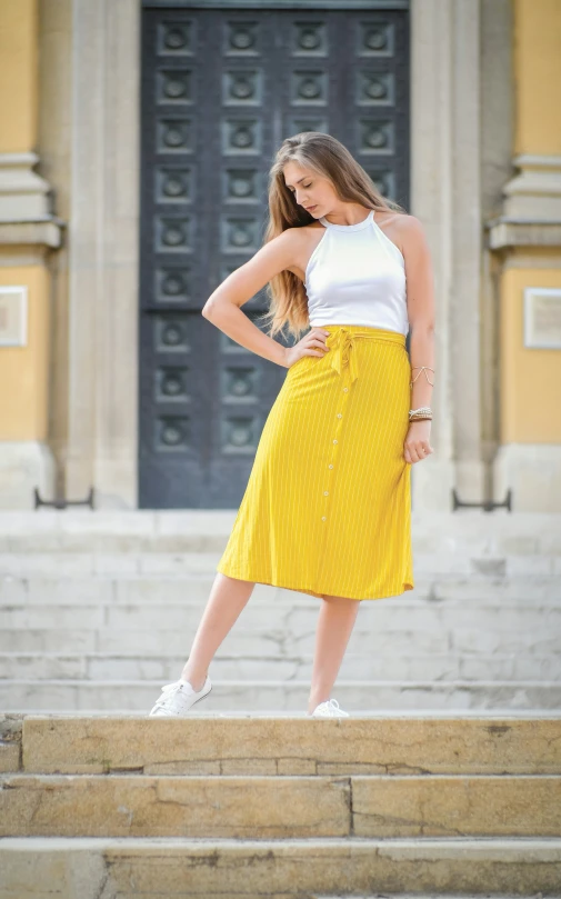 a woman posing for a picture in front of stairs