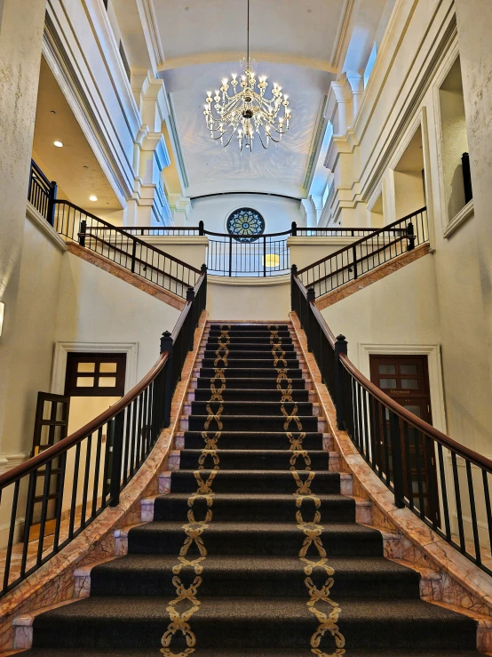 two large foyer staircases with chandelier and chandelier