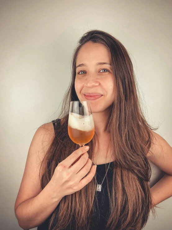 a woman holding a glass full of alcohol