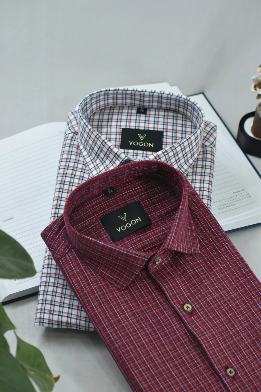 three plaid shirts sit on a table and one is red and blue, the other a white and blue checkerboard pattern