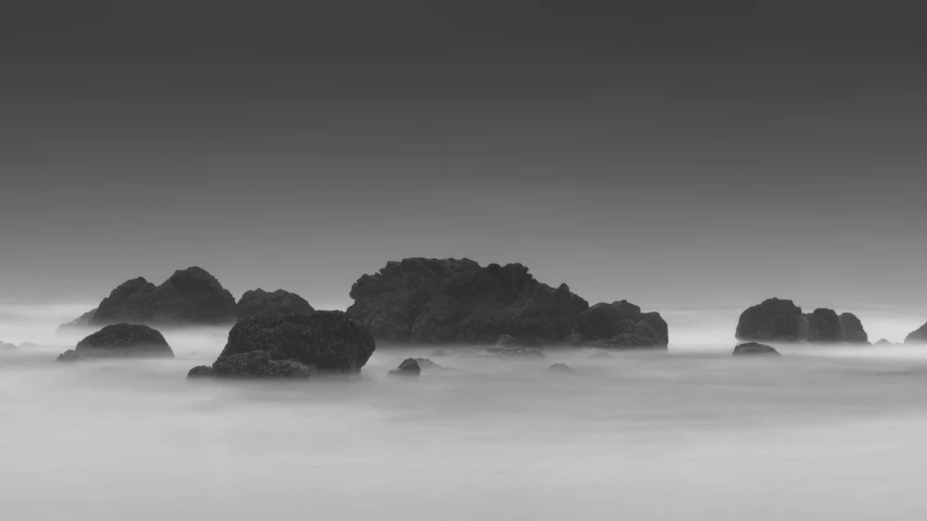 a black and white po of rock formations in the ocean