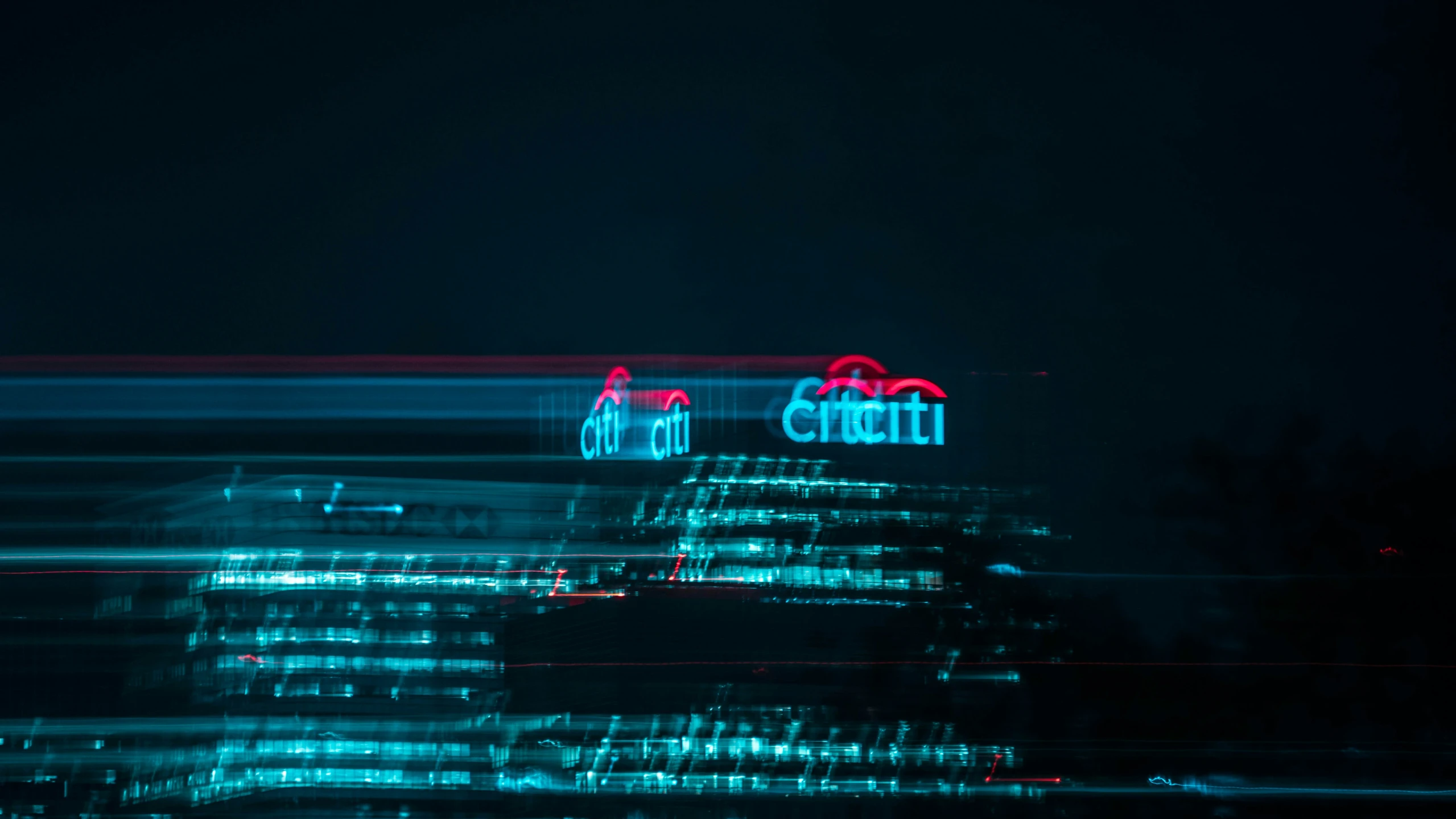 night view of cityscape and neon light at the top of a tall building