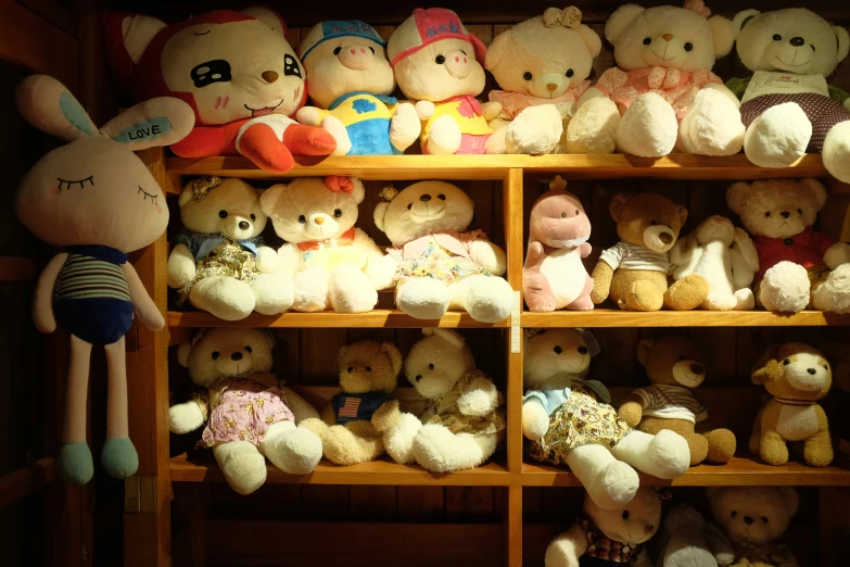 a wooden shelf covered with a variety of teddy bears