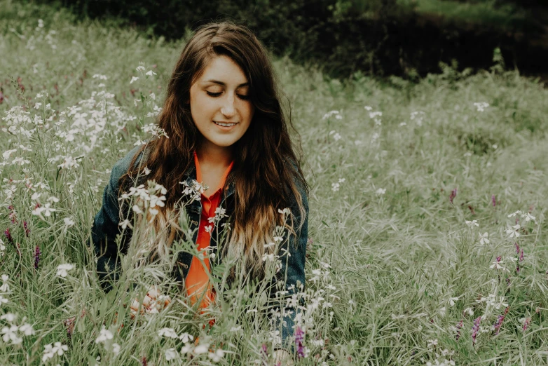 a woman in the middle of a field of flowers