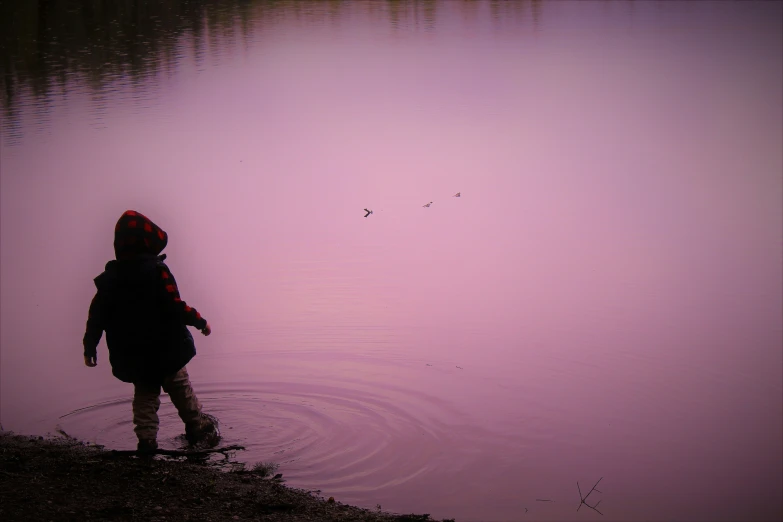 a little boy that is standing in the water