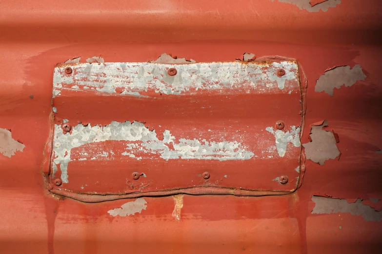 rusted metal plate on top of red and white paint