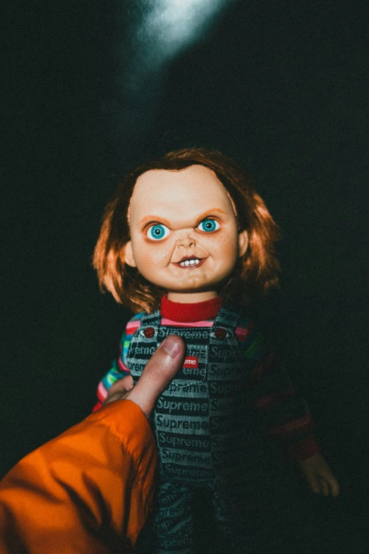 a doll with big eyes, being held by someone