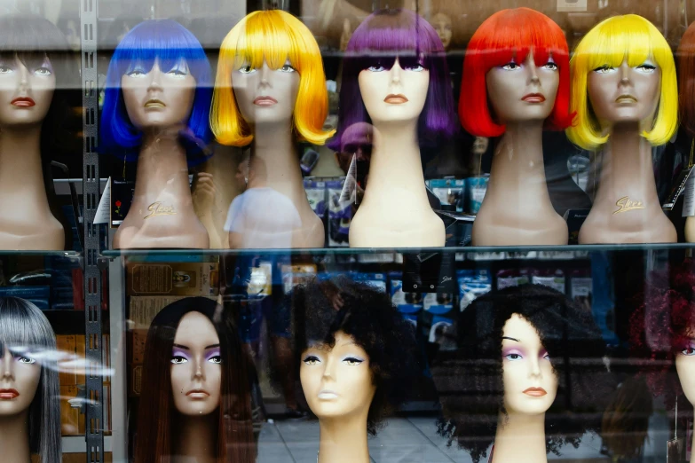 many different colored wigs are in a store