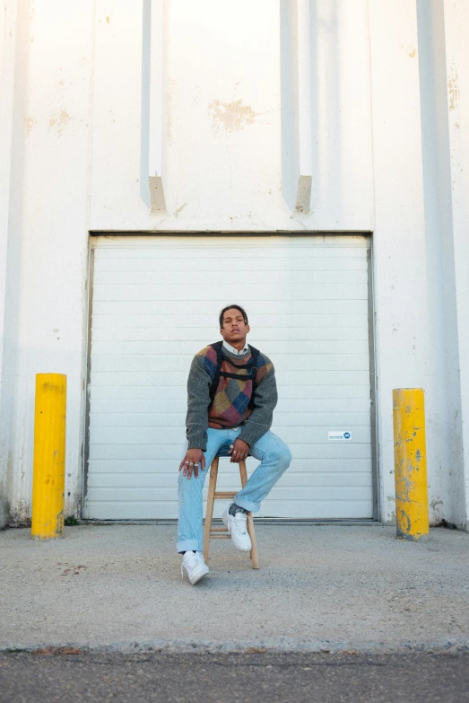 a person sitting on a skateboard in front of a garage