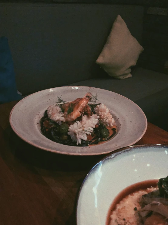 a plate of food sitting next to another bowl of food on a table