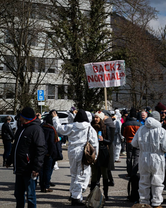 a group of people walking down a street with signs