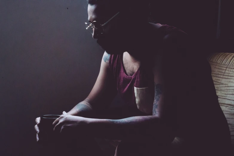 a dark po of a woman sitting on the bed