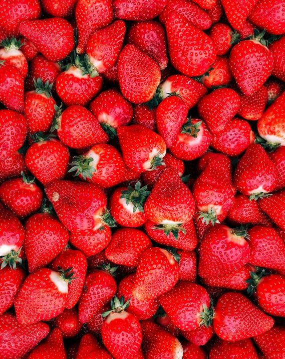 a pile of red fruit that is sitting on the floor