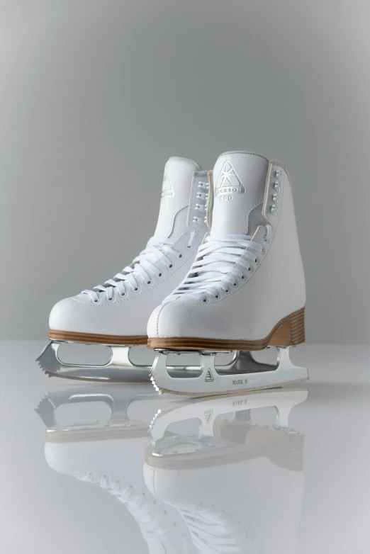 two white ice skates on a shiny surface