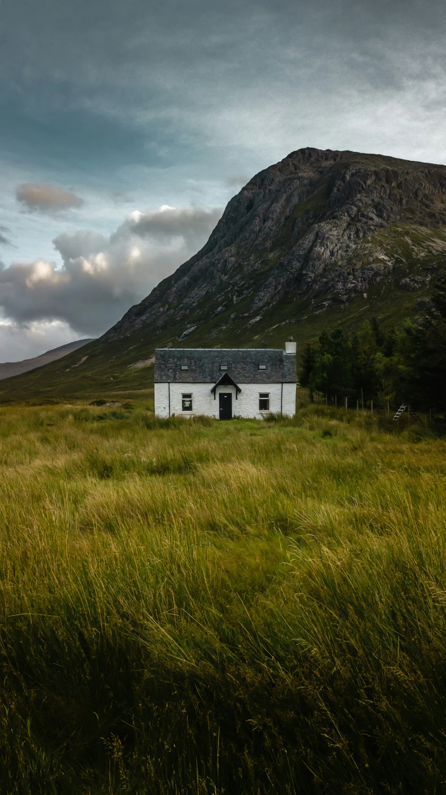 a house in the middle of a large mountain with a small building in the middle of it