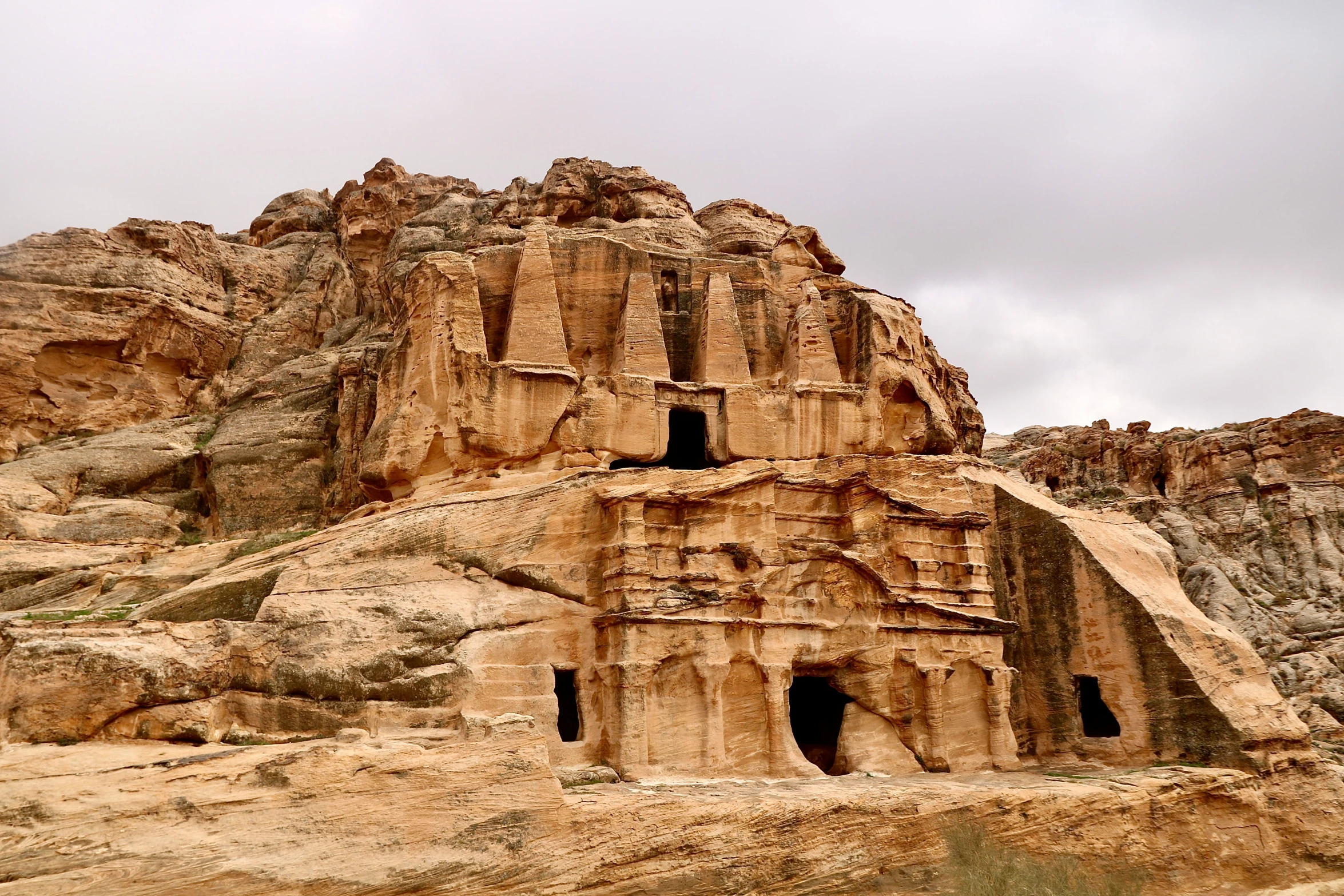 a large rocky outcrop with cave like structure with a doorway