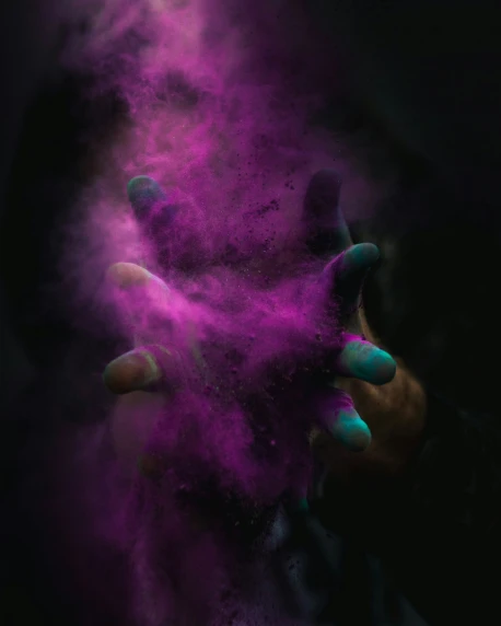 a persons hand holds purple powder