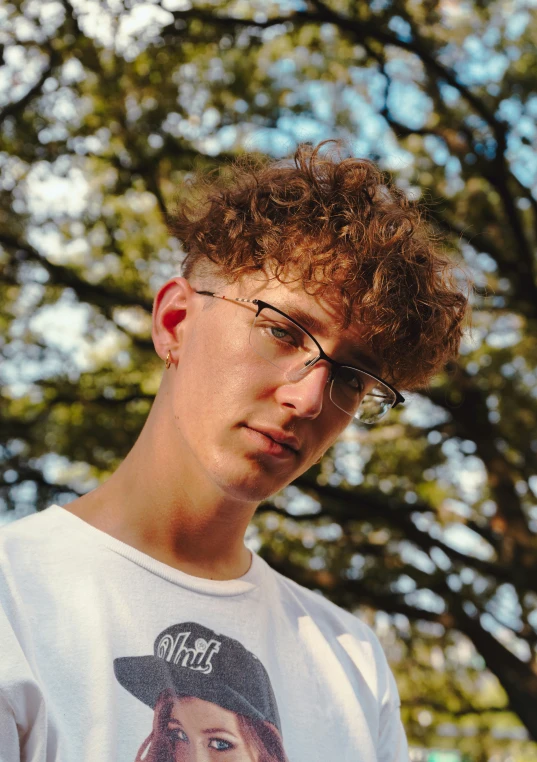 a young man wearing glasses and a hat is posing