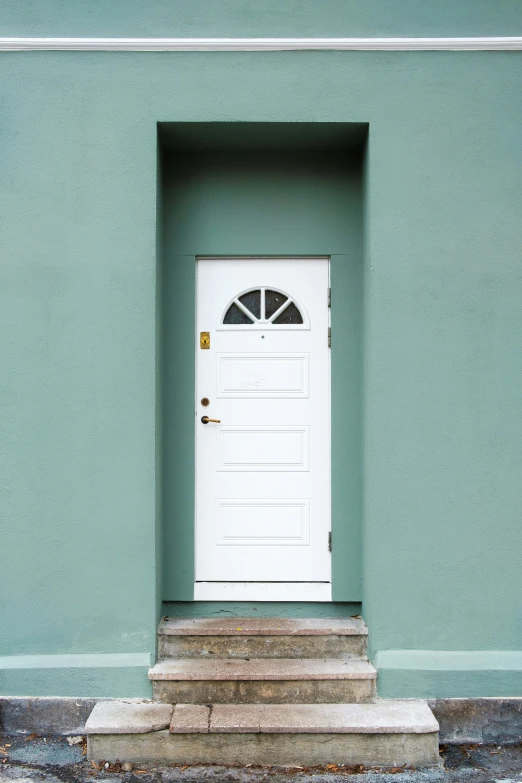 a door in front of a green building