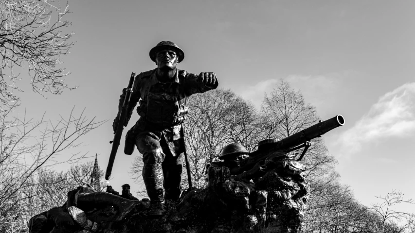 the statue is posed in a park with two soldiers