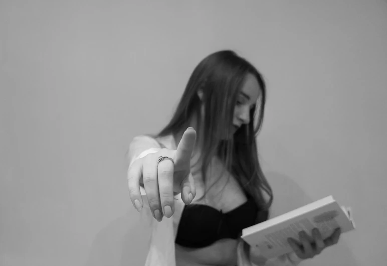 a woman is reading while holding a book